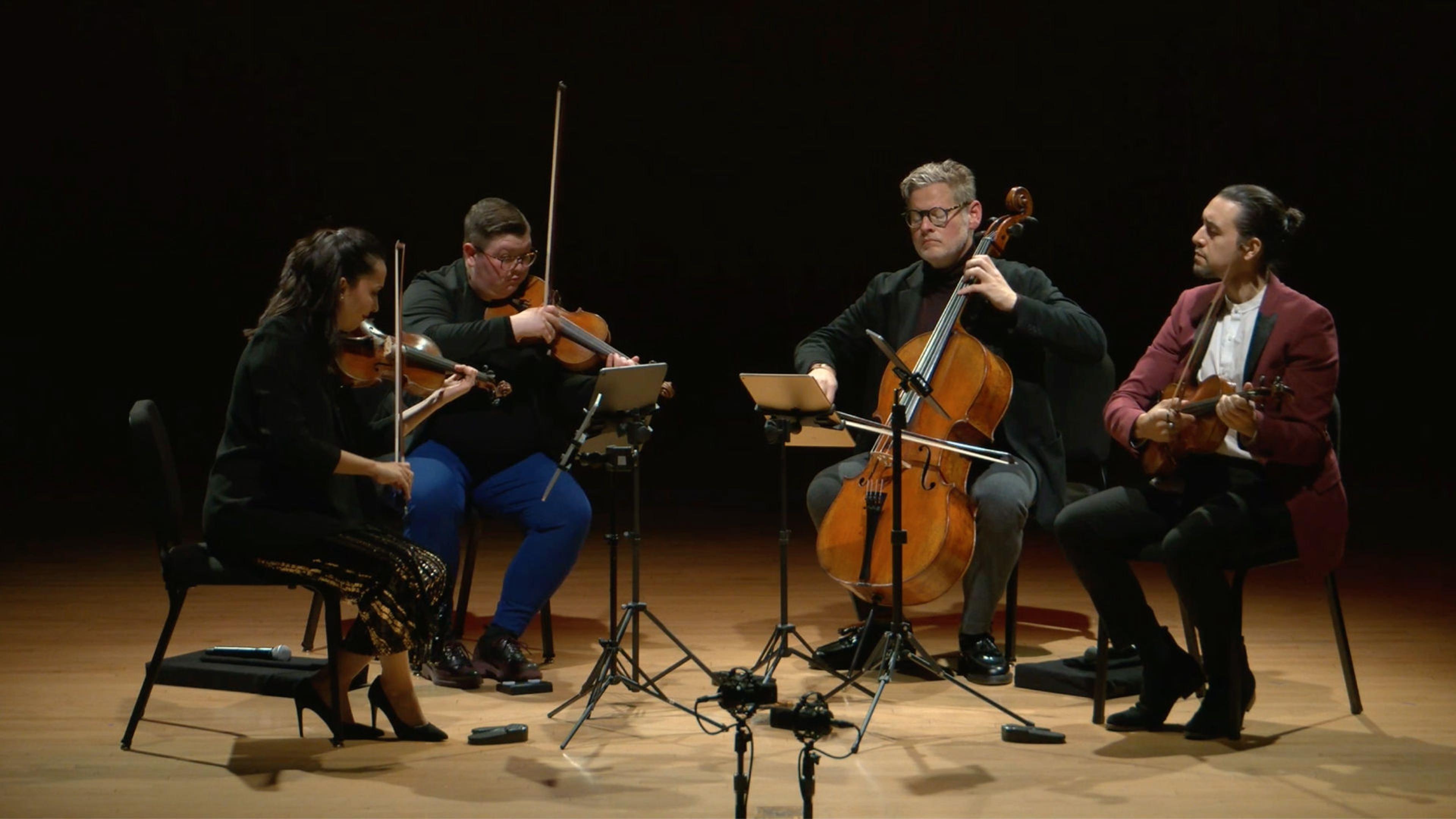 The Catalyst Quartet perform on a spotlit stage