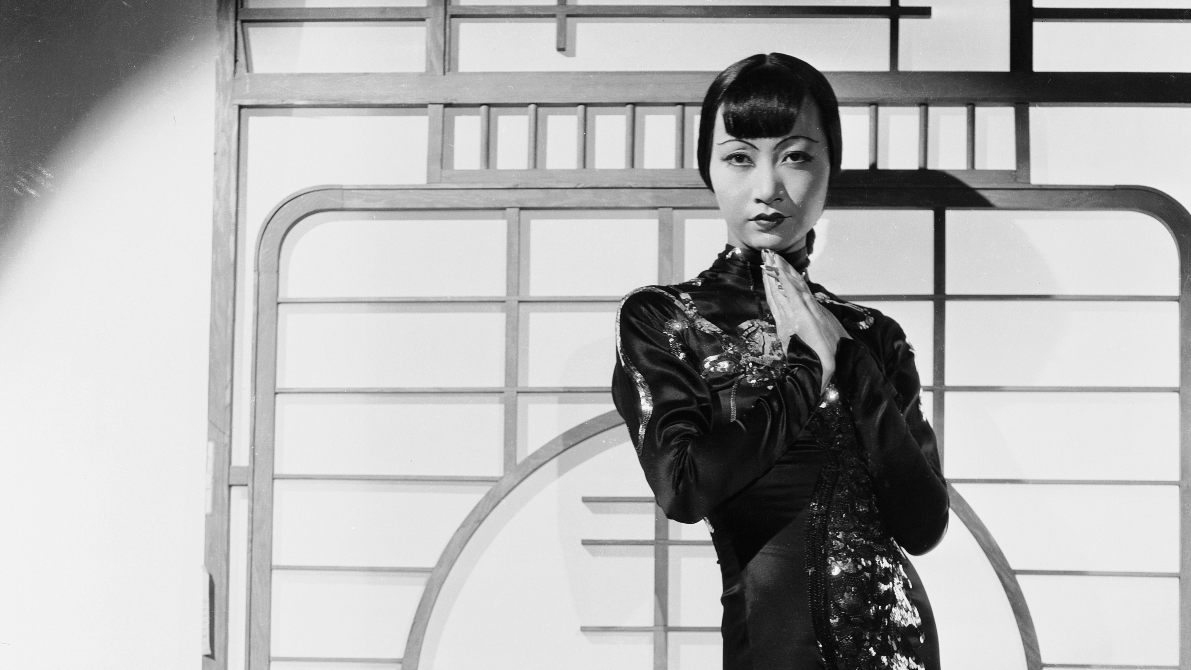 Black and white photo of woman posting where wearing a tradition Asian style dress.