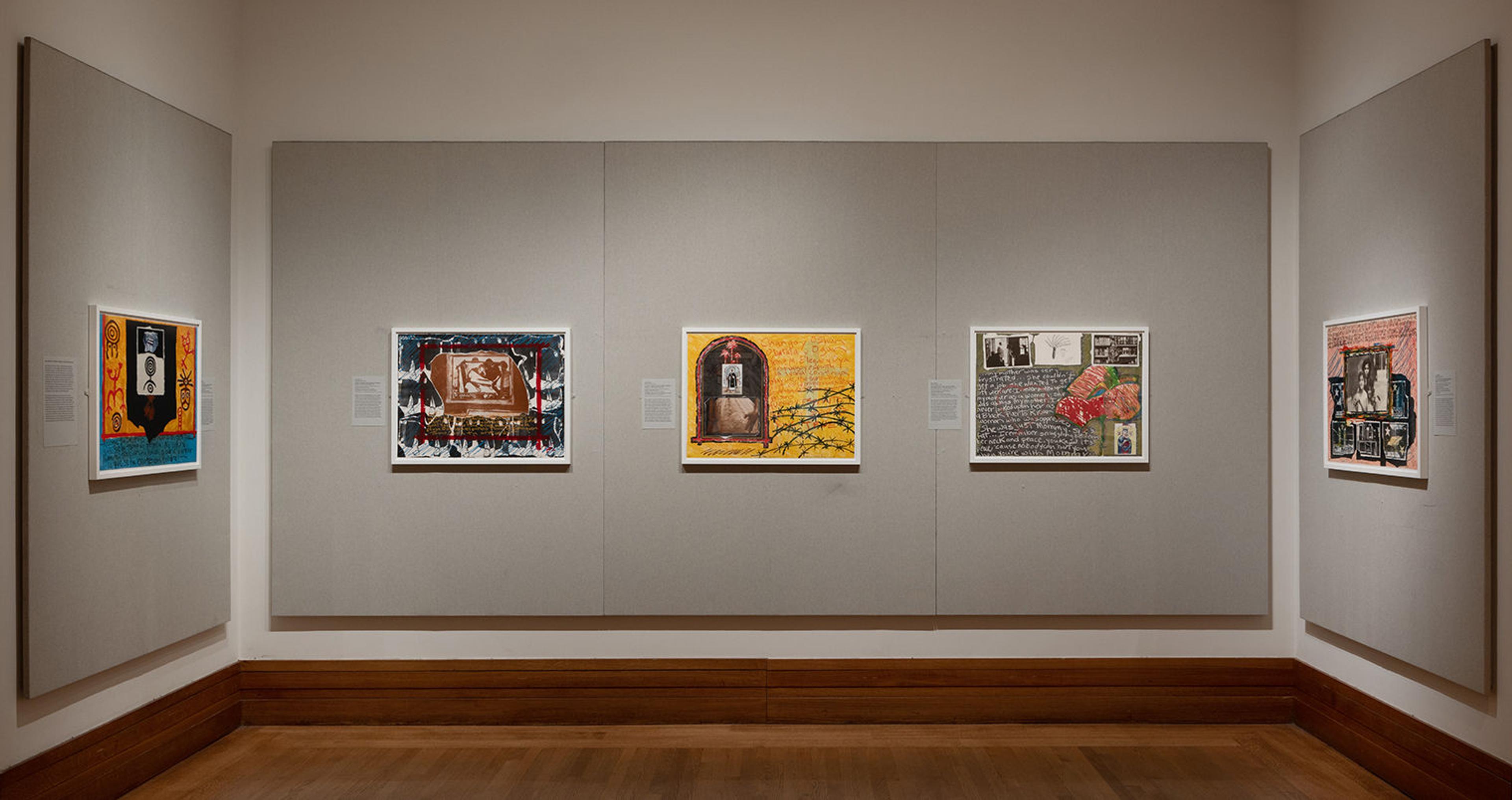 Three-walled bay of a gallery installation with five of Juan Sanchez's prints on display.