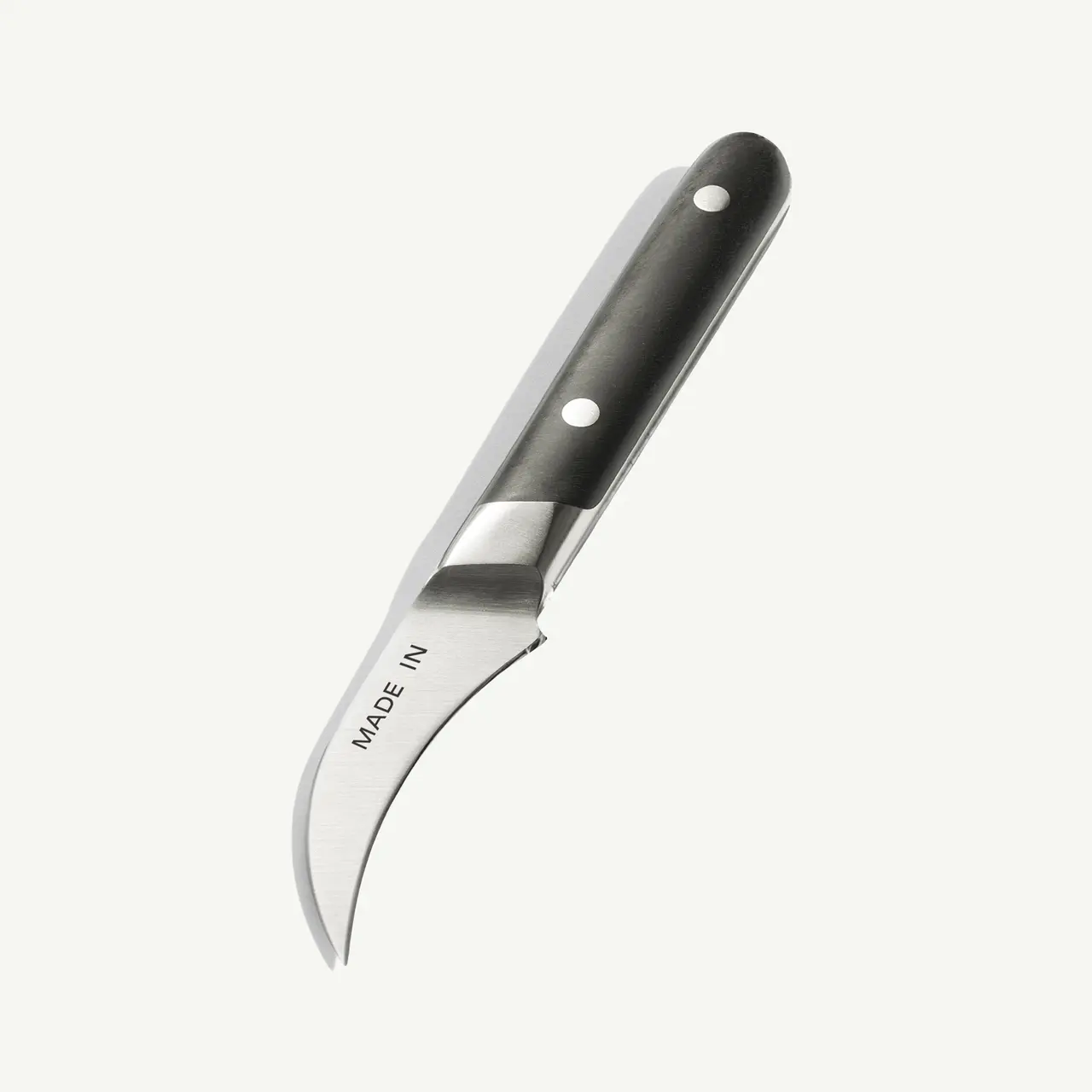 A curved kitchen knife with a black handle and the inscription "MADE IN."