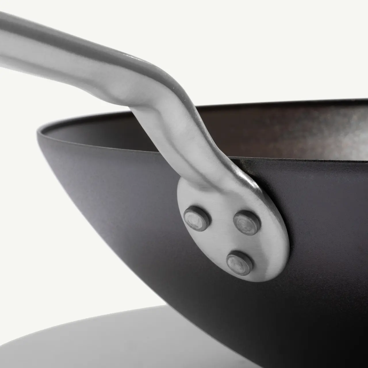 A close-up of a modern, black frying pan with a sleek metallic handle.