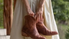 Woman in white dress holding pair of booties