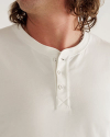 Man wearing a white henley in a photo studio
