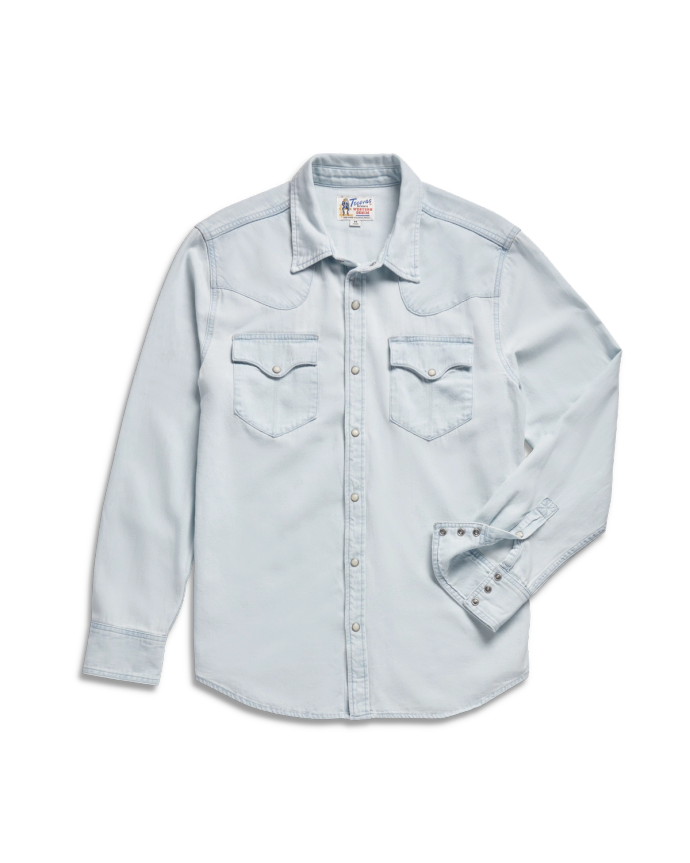 Light blue denim long-sleeve button-up shirt with two front chest pockets and pointed collar, displayed on a black background.